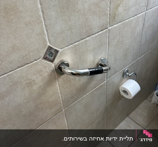 ידית אחיזה מותקנת על קיר אריחים בחדר אמבטיה